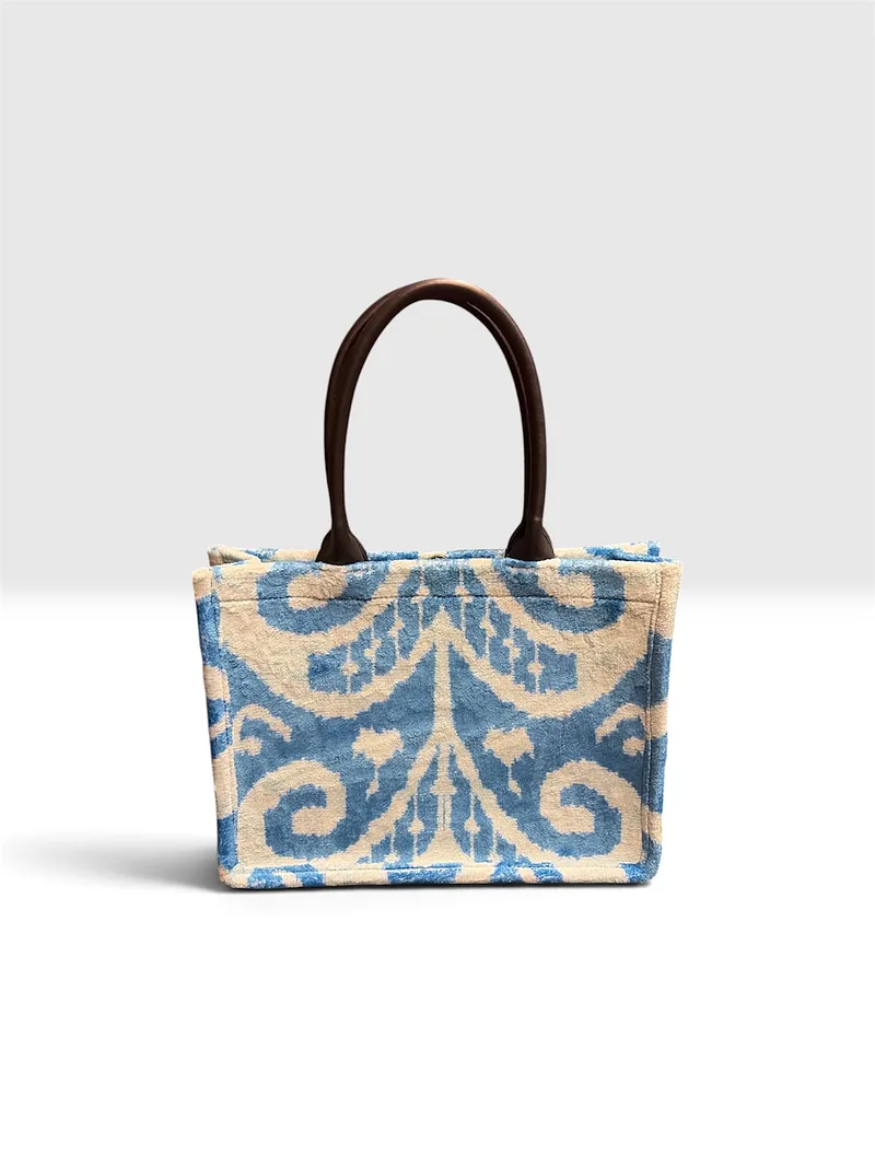 Kilim tote in an indigo-on-cream weave with rolled dark brown handles