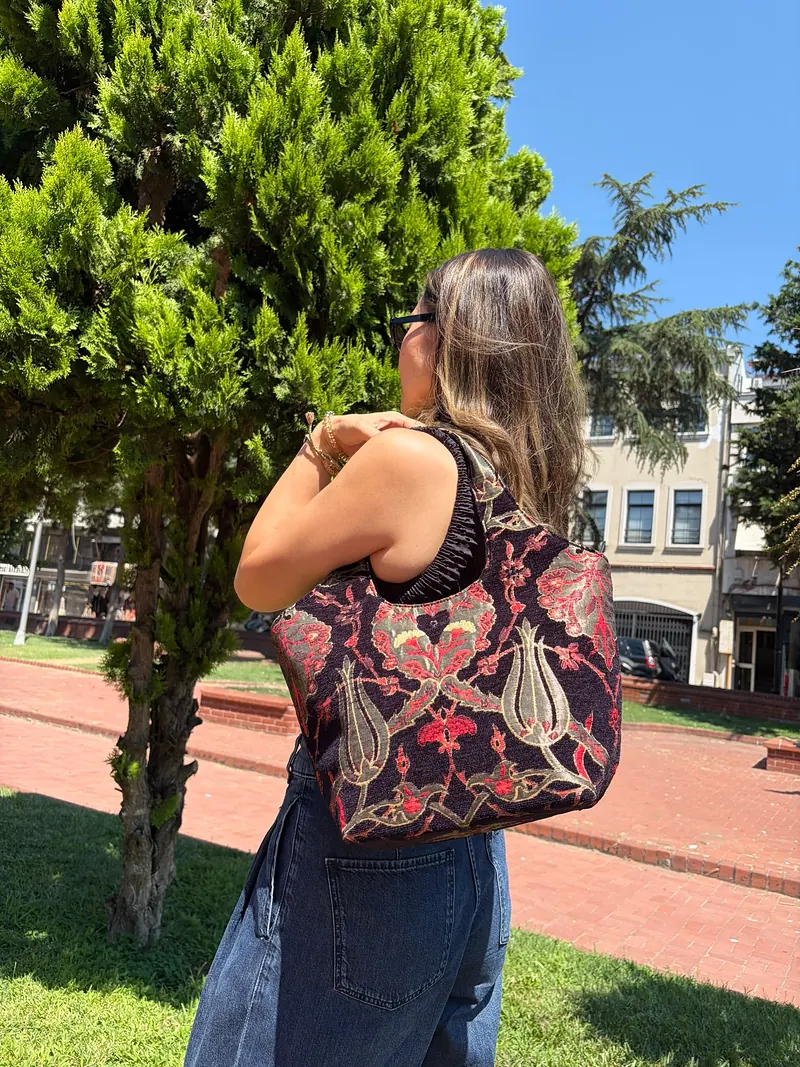 The ivory bag seen from behind, worn on the shoulder
