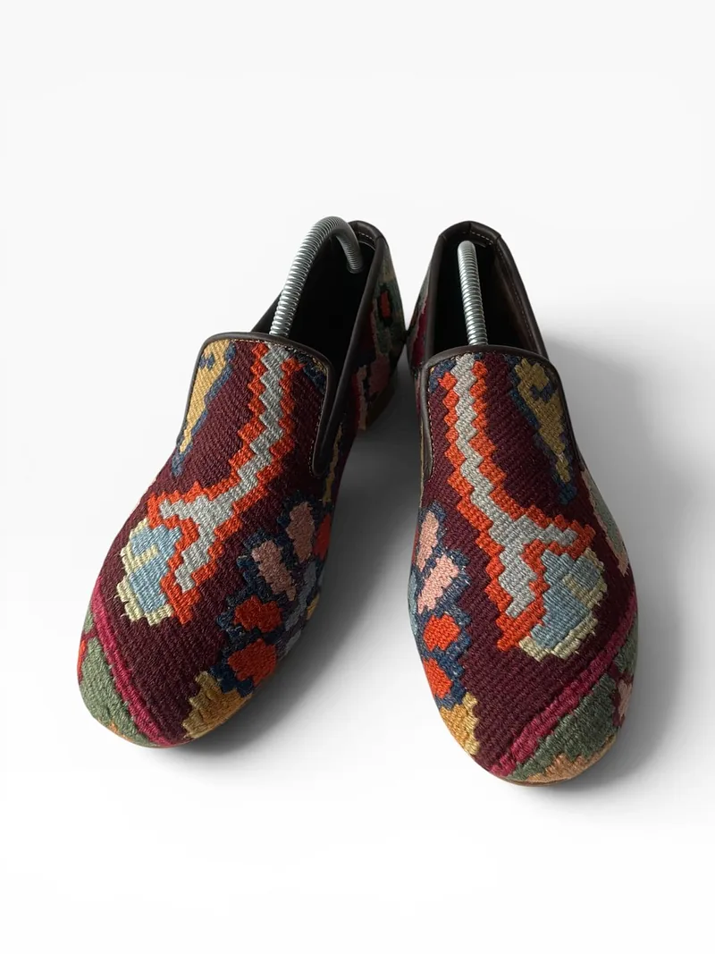 Uşak slip-on loafer on a plum ground with a saffron and orange running border