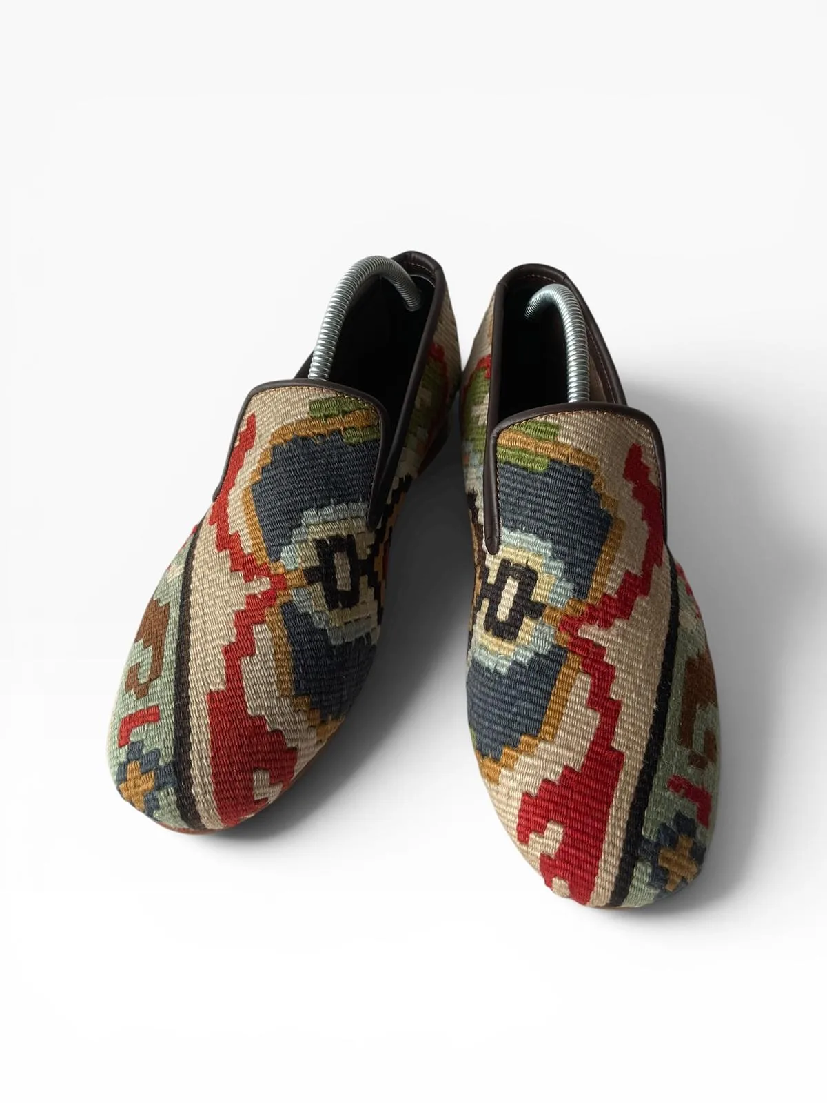 A kilim loafer with a sand and indigo medallion, photographed from above