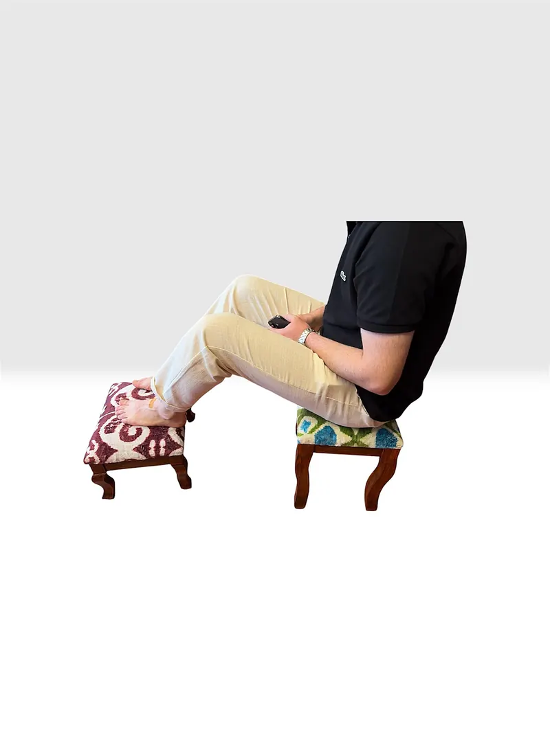 Feet resting on a stool beside a second one