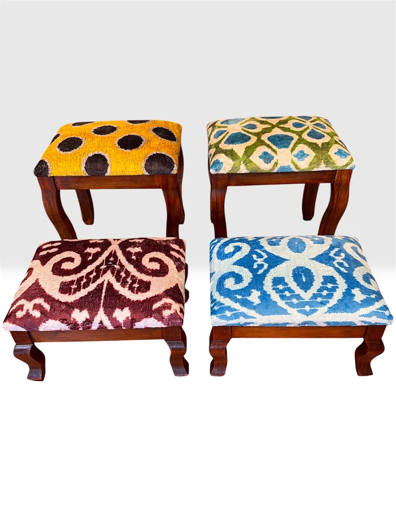 Four kilim stools on oiled walnut cabriole frames, their tops in garden lattice, saffron, burgundy and blue